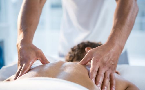 Woman receiving back massage from physiotherapist